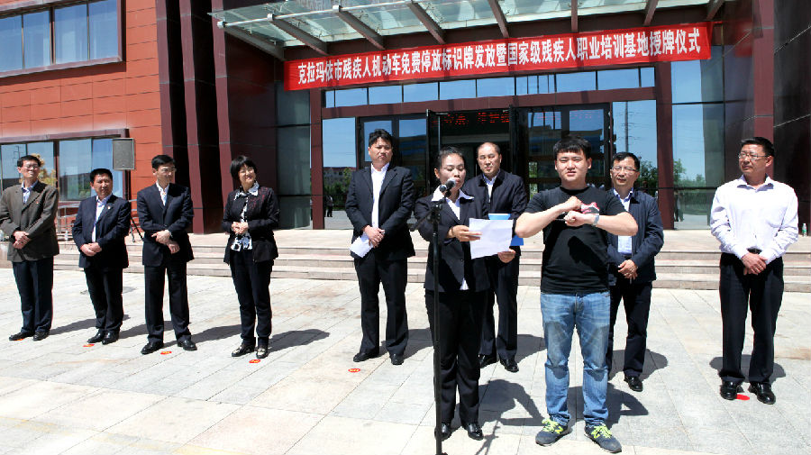 聋人协会主席屈程程打着手语.jpg