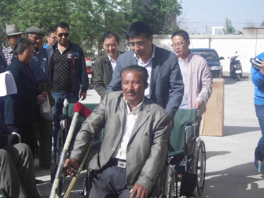 县人民政府副县长何淼在为残疾人发放轮椅