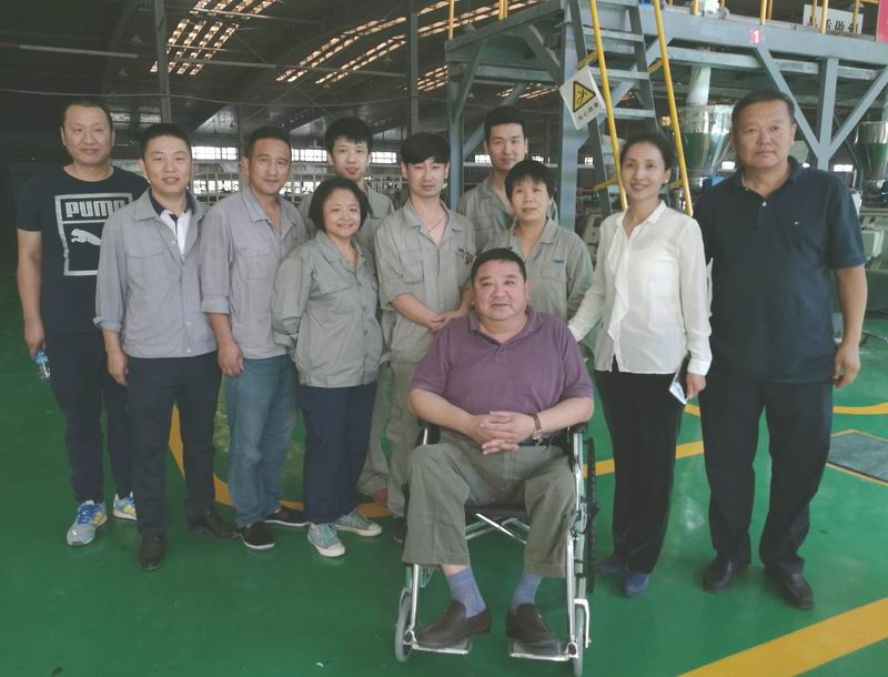 图为自治区残联副理事长胡志斌与企业残疾职工合影.jpg
