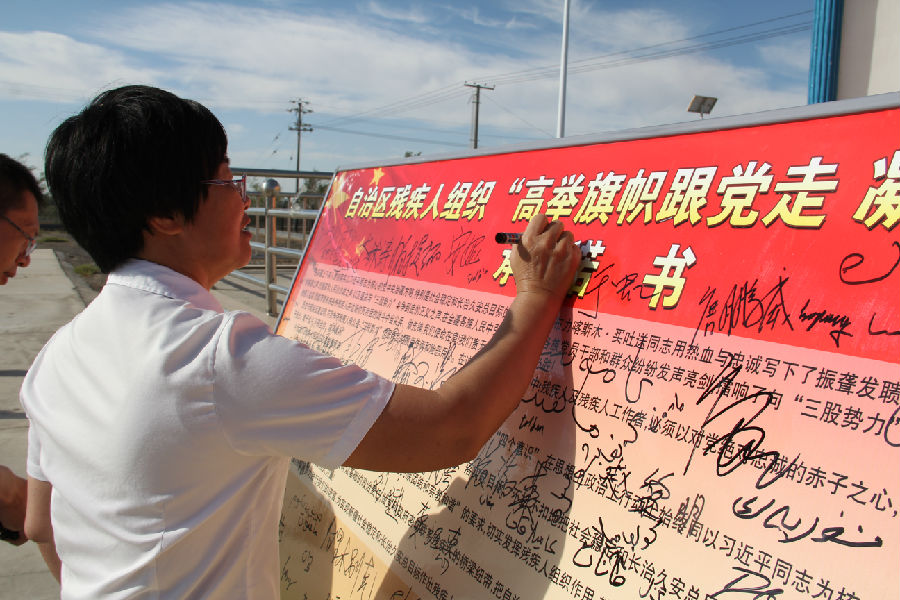 残联党组副书记、理事长侯菊香在承诺书上签字.jpg