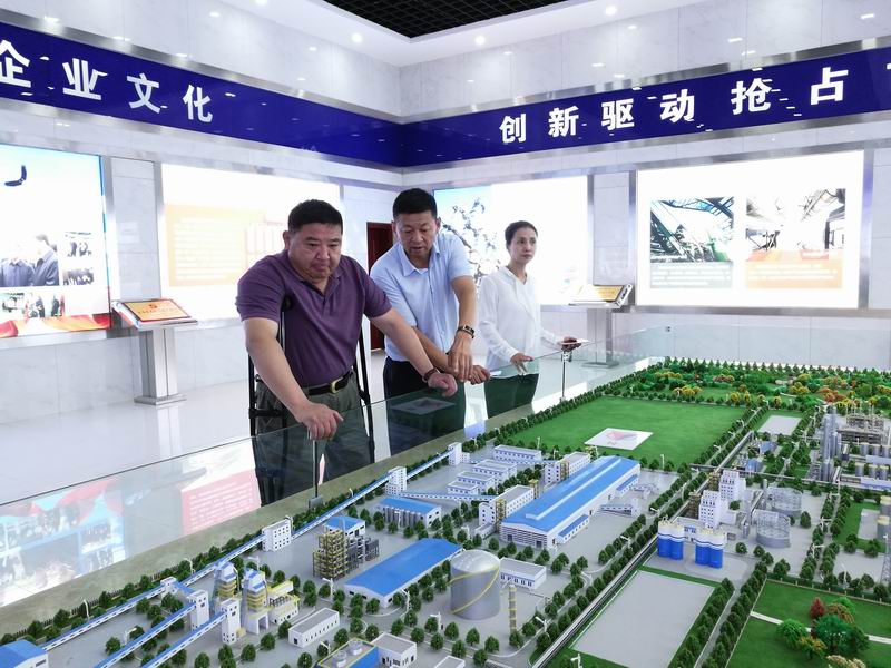 图为自治区残联副理事长胡志斌在听取企业负责人介绍企业发展情况.jpg