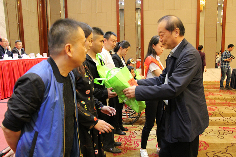 自治区残联党组书记、理事长周俊林为残疾人发放受捐赠的衣物_副本.jpg