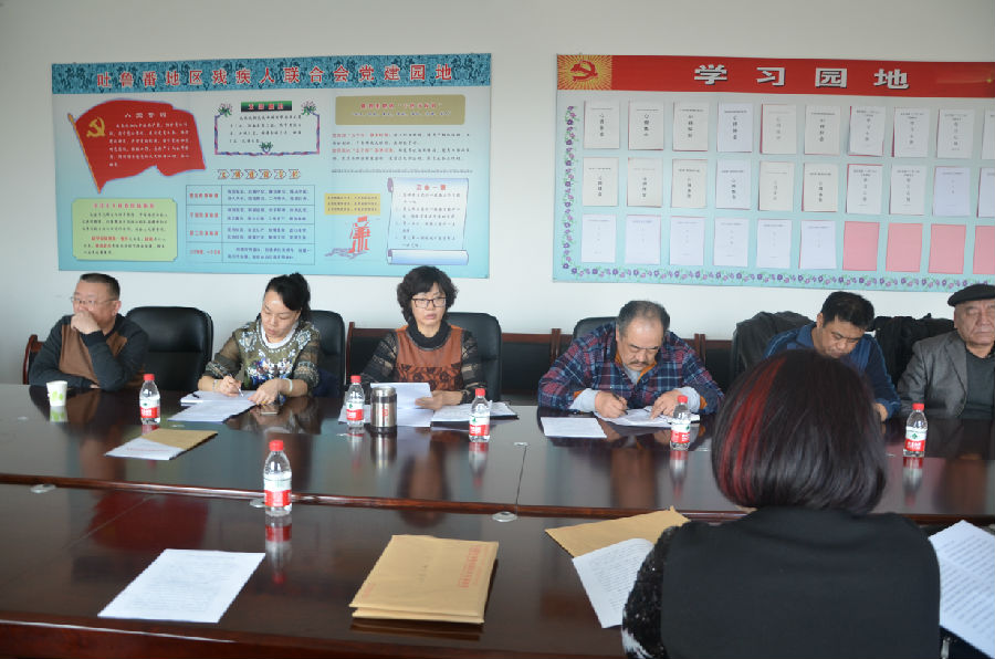 图为市残联理事长魏礼青做汇报